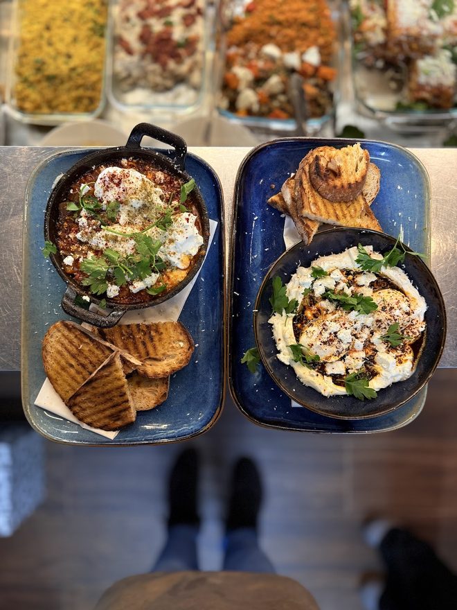 Two bowls of baked eggs with flatbread and pitta