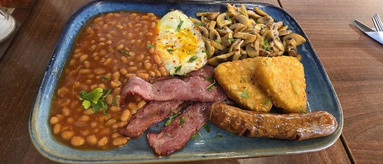 Full English breakfast with bacon, sausage, egg, beans and mushrooms