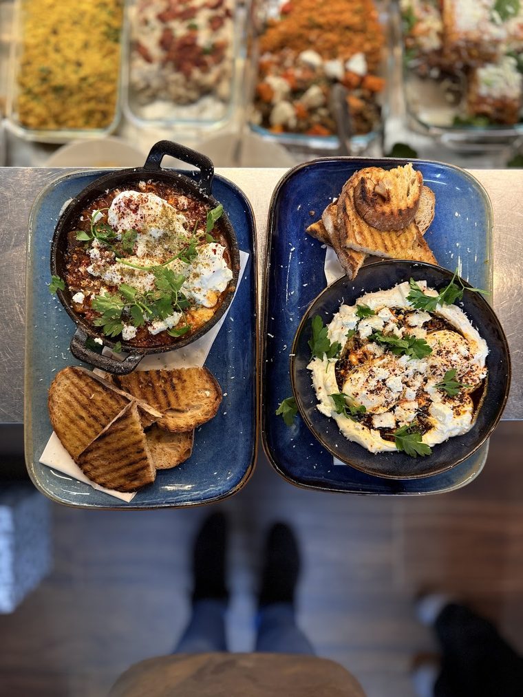Baked eggs in tomato sauce with toasted flatbread, cropped to the bowls