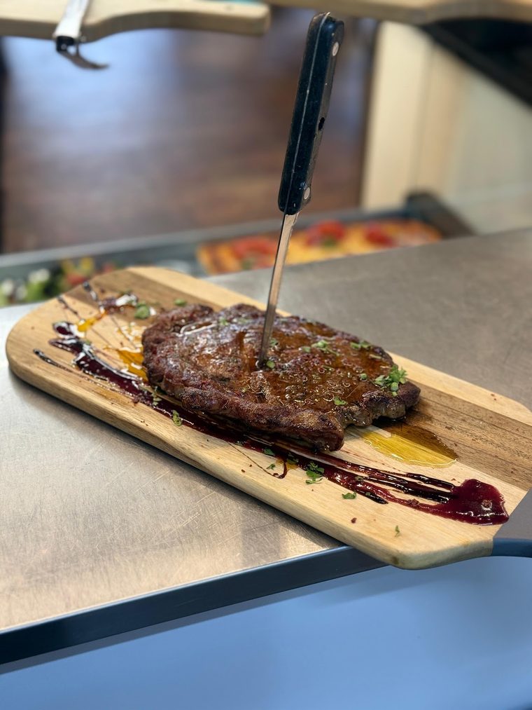 Sirloin steak with sauce on a wooden board